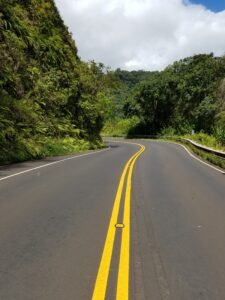 photo of a twisting road with two yellow lines